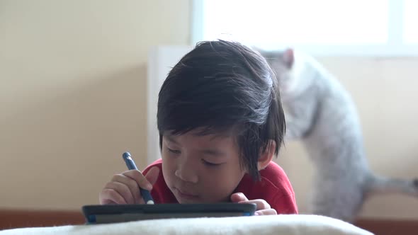 Asian Child Drawing Picture With Digital Pen On Tablet Pc Computer