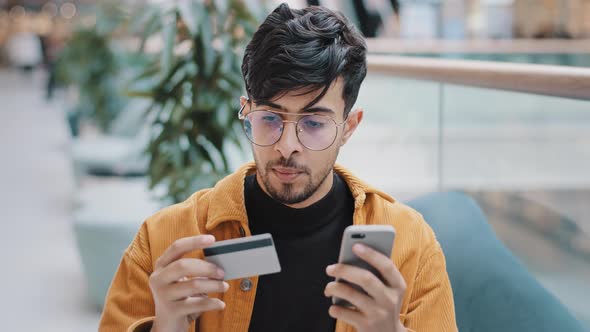 Focused Man Carefully Entering Banking Credit Card Data in Phone Using Mobile App Pays Purchase