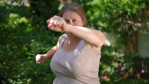 Motivated Concentrated Plussize Female Boxer Fighting Shadow Looking at Camera with Confident Facial