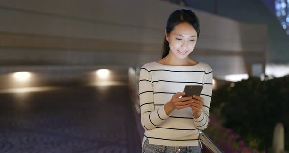 Woman looking at mobile phone at night 