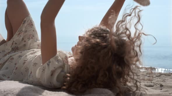 Relaxed Girl Covering Face with Straw Hat Lying on Beach Close Up