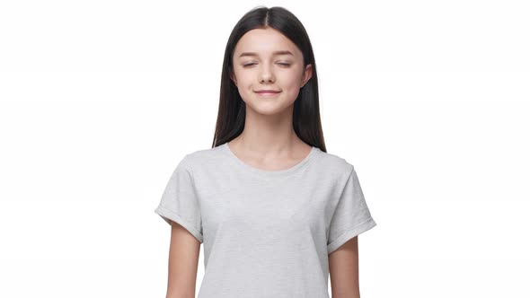 Portrait of Lopeared Caucasian Woman with Long Dark Hair in Basic Tshirt Looking at Camera with