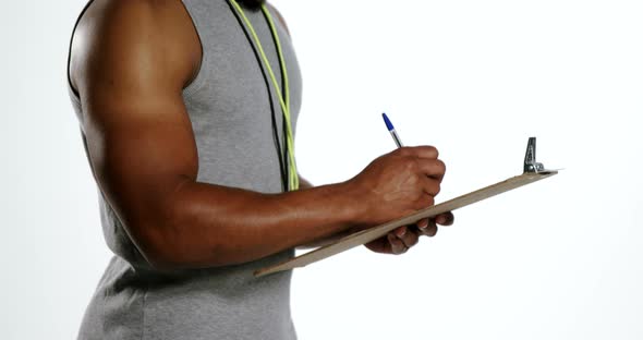 Attentive trainer writing on clipboard