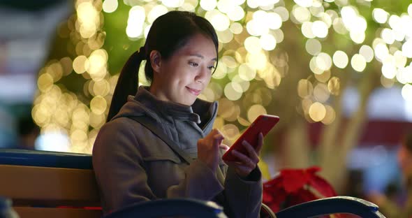 Woman use of cellphone with Christmas decoration 