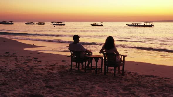 Man and woman tan on exotic coast beach wildlife by blue lagoon and white sand background of Indones