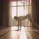 A Young Woman in White Sportswear is Stretching with a Large Hall with Large Windows in a Slowmotion - VideoHive Item for Sale