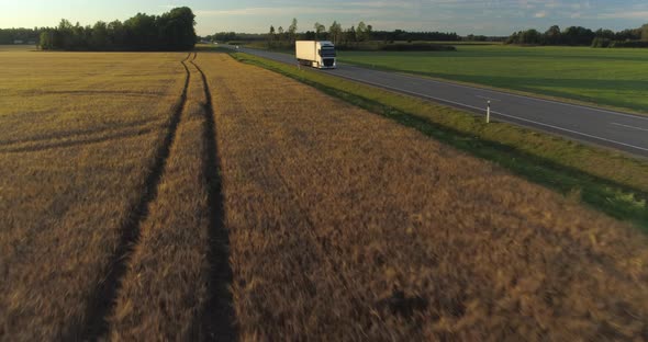 Aerial View of Cargo Truck Delivering Goods on Highway in Countryside at Sunset