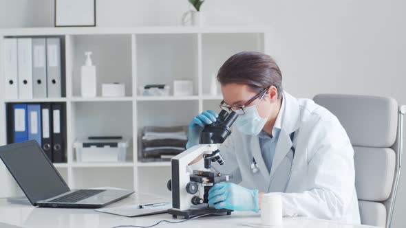 Professional medical doctor working in hospital office using computer technology.