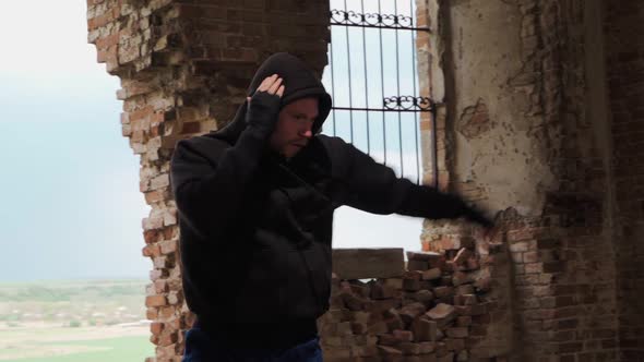 Man boxer in the hood trains beats in an abandoned building. Shadow Boxing. Slow motion.