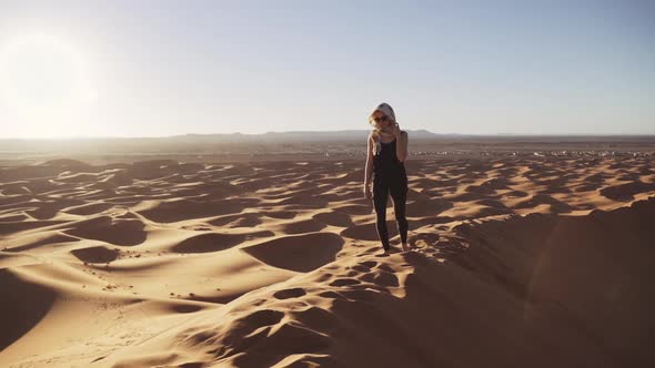 Tourist Walking Barefoot Over Sand Dune In Desert