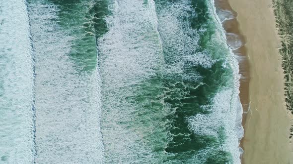 Aerial Top View on Ocean Waves and Sand Beach