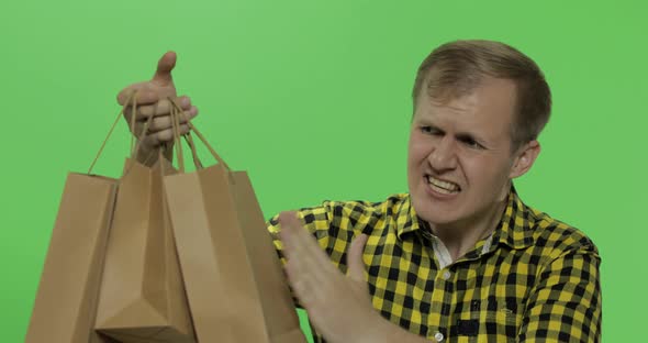 Angry Aggressive Young Man with Shopping Bags. Chroma Key