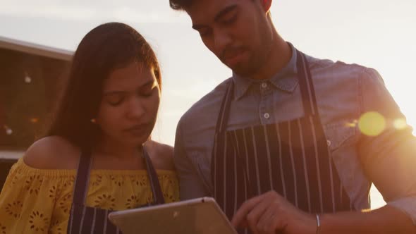 Young couple looking at the touch pad by food truck