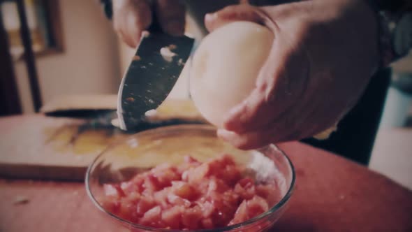 hands close up cutting a onion in small pieces to make salad