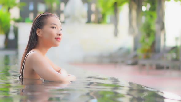 Young asian woman enjoy around outdoor swimming pool for leisure