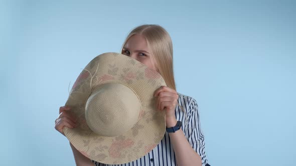 Attractive Young Lady Hiding Behind the Hat and Blinking Her Eyes