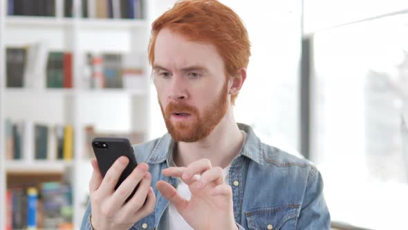 Casual Redhead Man Reacting To Loss in Smartphone