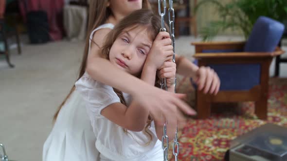 Two Beautiful Girls Rides on a Swing and Cuddle