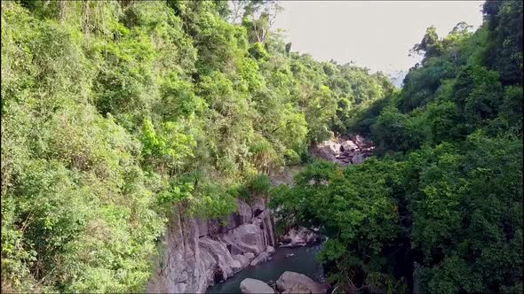 Drone Flies Over Canyon with Trees Cliffs and River