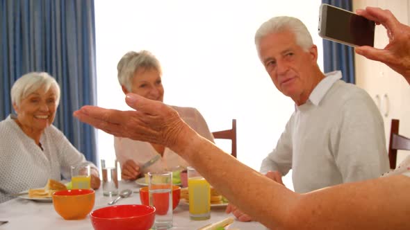 Woman photographing her senior friends