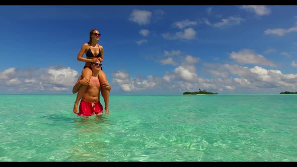 Boy and girl tanning on tropical seashore beach vacation by clear sea and white sandy background of 