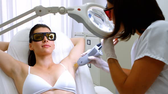 Doctor performing laser hair removal on patient skin