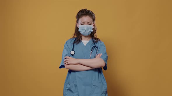 Medical Doctor Standing Posing Confident with Arms Crossed Removing Surgical Mask