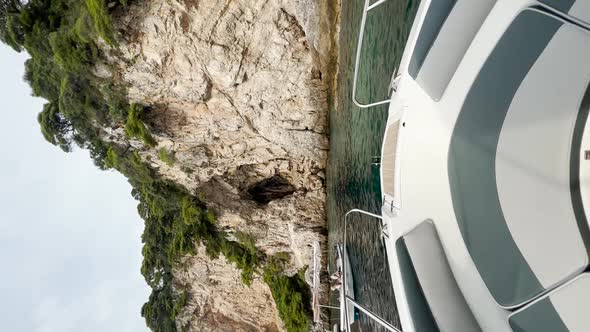 Boat parked up beside The Blue Cave with beautiful rocky cliffs ahead at The Kolocep Island, Croatia