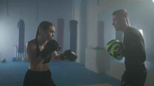 Female Fighter Trains His Punches and Defence Punching Focus Mitts Training Day with a Man Coach in