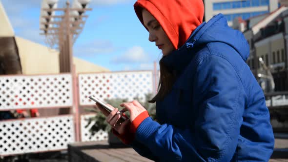 Poor Girl Student Sitting and Looking at Her Smartphone