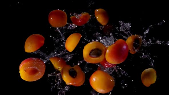 Halved and Whole Apricots Bouncing Towards the Camera