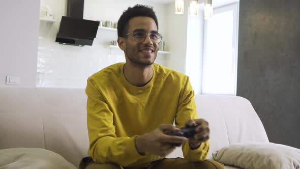 African Boy Plays with a Joystick at Home