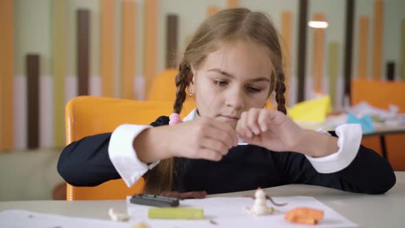 Portrait of Concentrated Schoolgirl Sculpting Plasticine in School