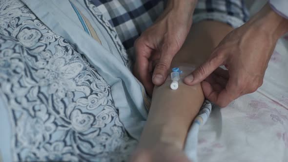 The Doctor Installs a Catheter to a Woman Who is in the Hospital