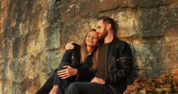 Romantic Couple in Love Relaxing in Embraces at Stone Wall, They Have Joy