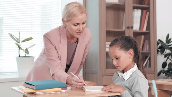 Teacher Helping Student in Class