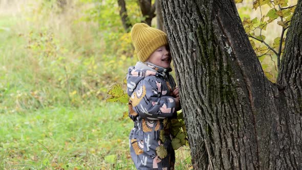 Cute Little Girl Hiding Behind a Tree