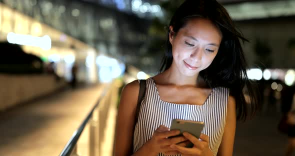 Woman using smart phone at night 