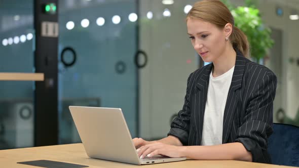 Appreciative Young Businesswoman with Laptop Saying Yes By Head Shake