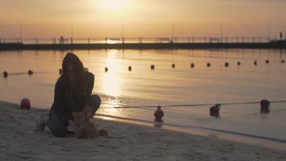 Female on the Beach Enjoying Sunrise with Dog