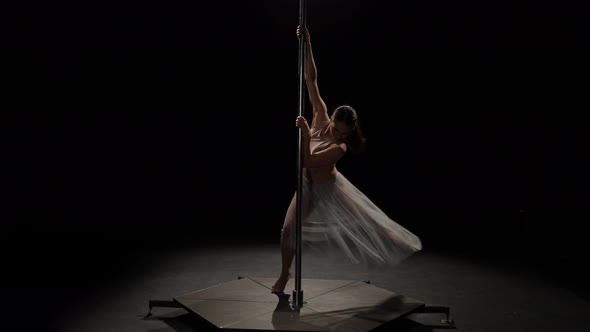 Sexy Girl Dancing Sensual Dance on the Pylon. Black Background