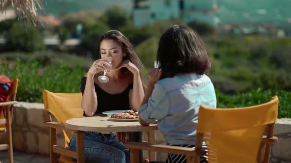 Two Girls Drinking Wine in Cafe Seaside