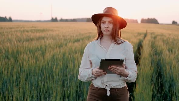 Agronomist Farmer Woman Using Tablet Computer in Golden Wheat Field. Farm Worker in Wheat Plantation
