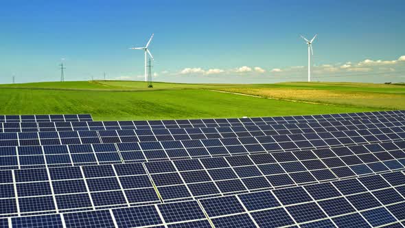 Solar Panels and wind turbines on green field, aerial view