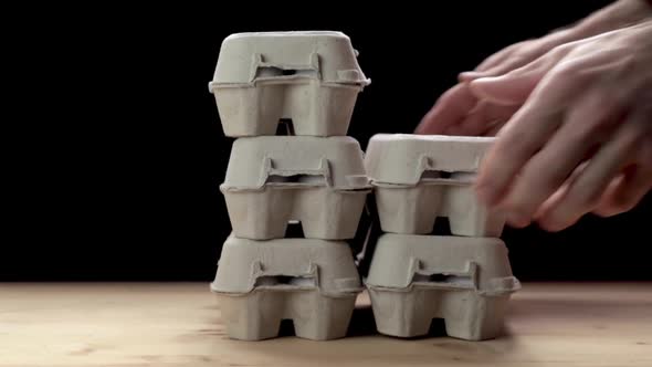 Man Stacking Egg Paper Packaging. Slow Motion.