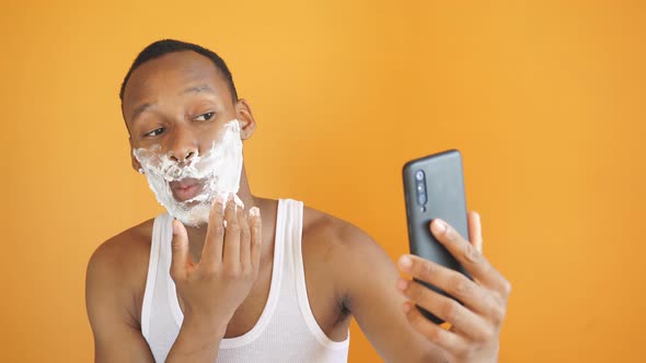 Nice Person with Dark Skin Applies Shaving Foam To the Face Before Shaving the Stubble