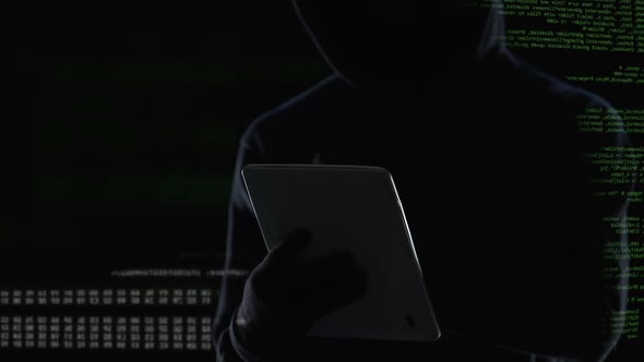 Dark Man Typing on Tablet Computer, Illegal Attack on Privacy, Cybercrime