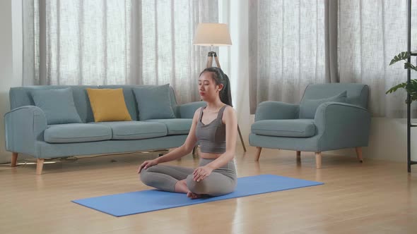 Young Asian Athletic Female Meditating During Workout On Yoga Mat At Home. Healthy Lifestyle