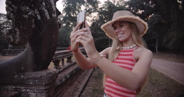 Young Blonde Attractive Female Model Taking a Picture With an Afternoon Sky