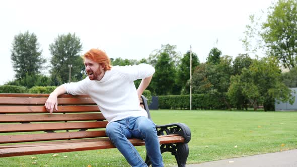 Tired Man with Back Pain, Spinal Pain, Sitting on Bench, Red Beard and Hairs